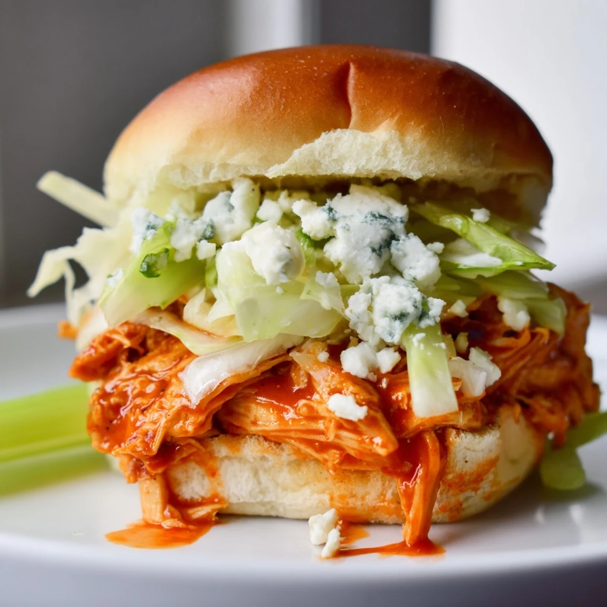 Golden shredded chicken tossed in zesty Buffalo sauce, topped with creamy blue cheese spread and crisp lettuce, layered on toasted slider buns for a delicious game day treat.  