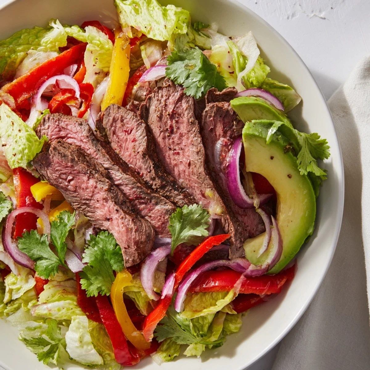 Colorful Tex-Mex salad featuring warm beef, crunchy vegetables, and cilantro, perfectly dressed and ready to serve for dinner.