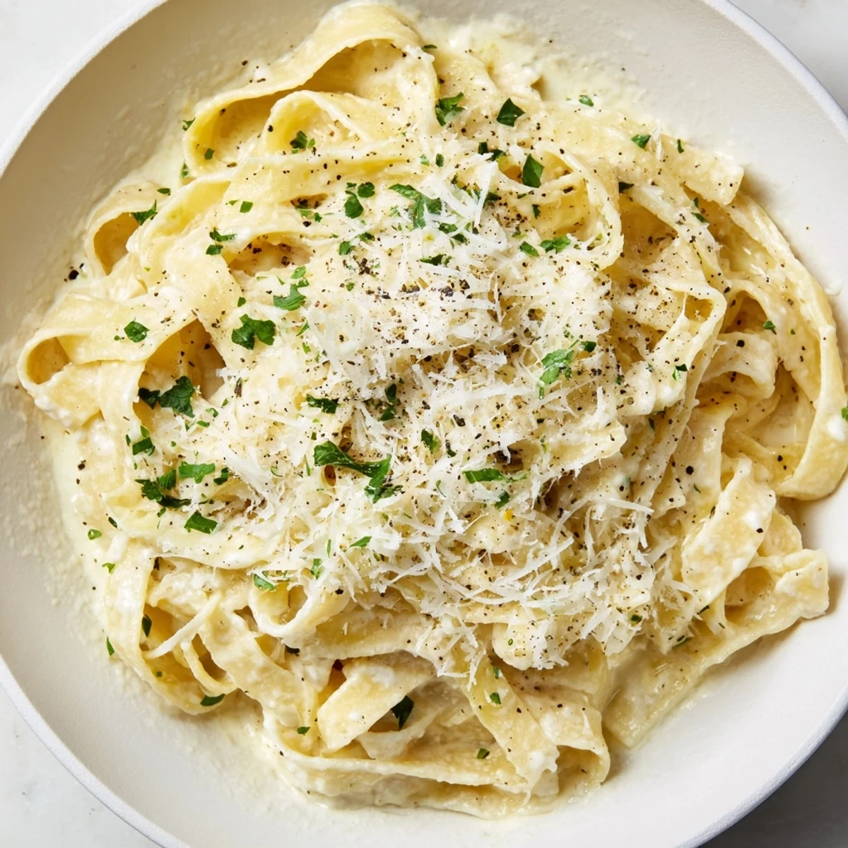 Serving of Creamy Garlic Pasta with Herbs alongside a glass of white wine and crusty bread.