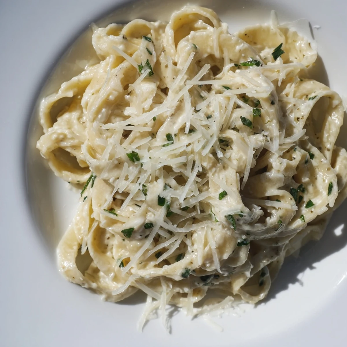 Steaming plate of Creamy Garlic Pasta with Fresh Herbs tossed in a rich garlic cream sauce with Parmesan.