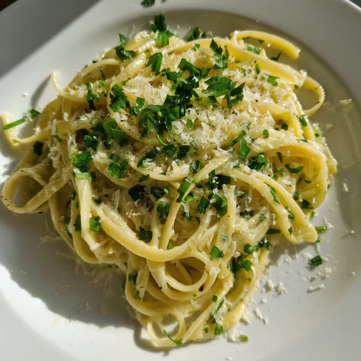 Steam rises from a skillet of Creamy Garlic Pasta with Fresh Herbs, next to a glass of white wine.
