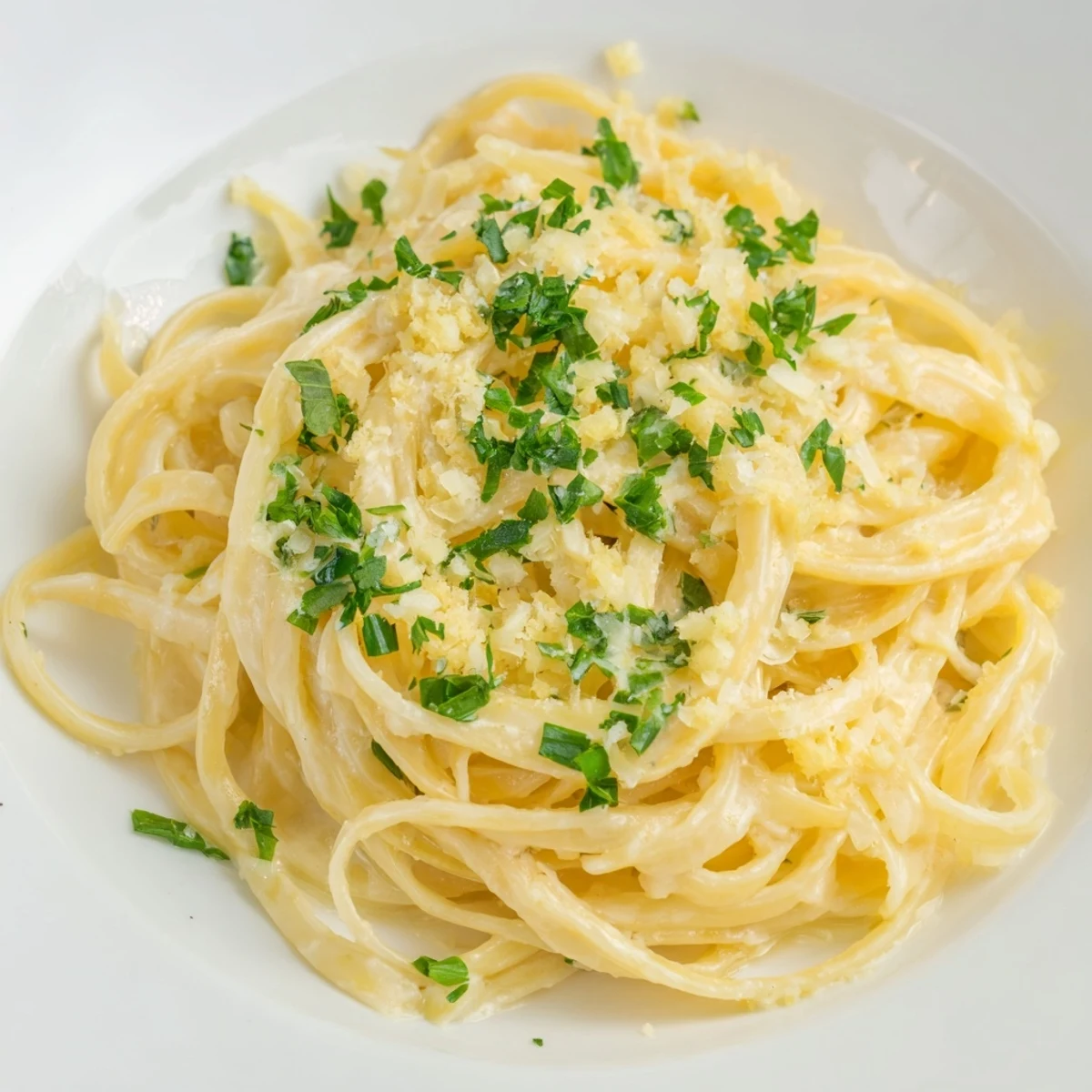 Fresh parsley and basil garnish the Creamy Garlic Pasta with Fresh Herbs in a warm ceramic bowl.