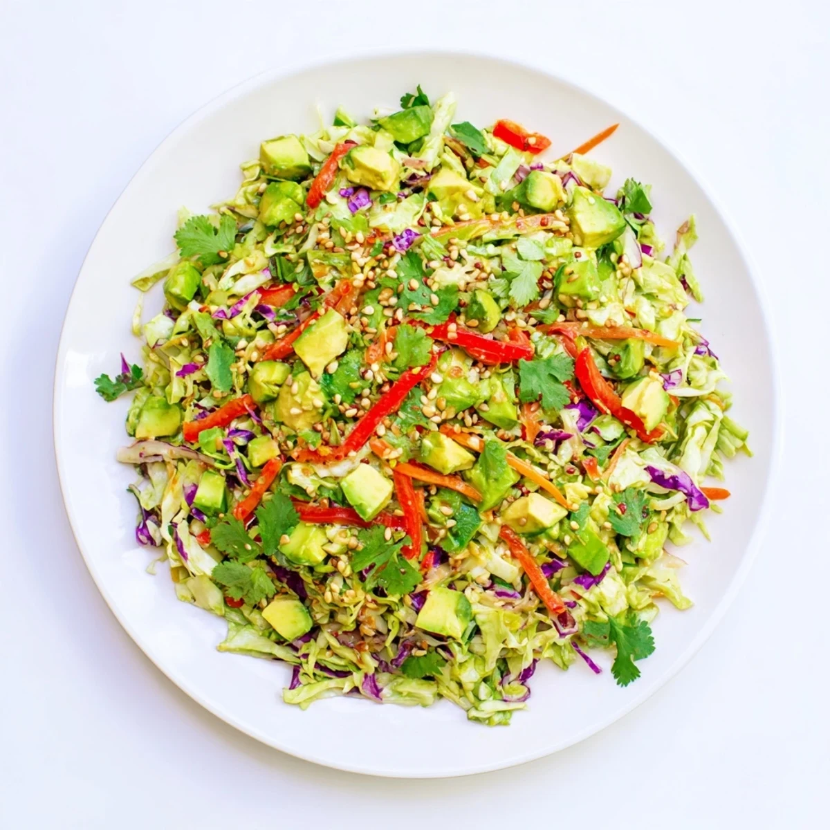 Healthy vegan Avocado Cabbage Salad ready to eat, sprinkled with toasted pumpkin seeds and fresh cilantro for a flavorful light lunch.