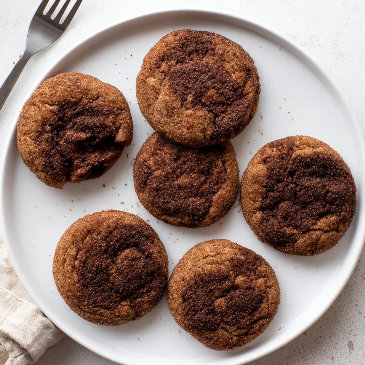Soft-baked Chocolate Snickerdoodles stacked on a rustic wooden board, highlighting their rich chocolate color and texture.
