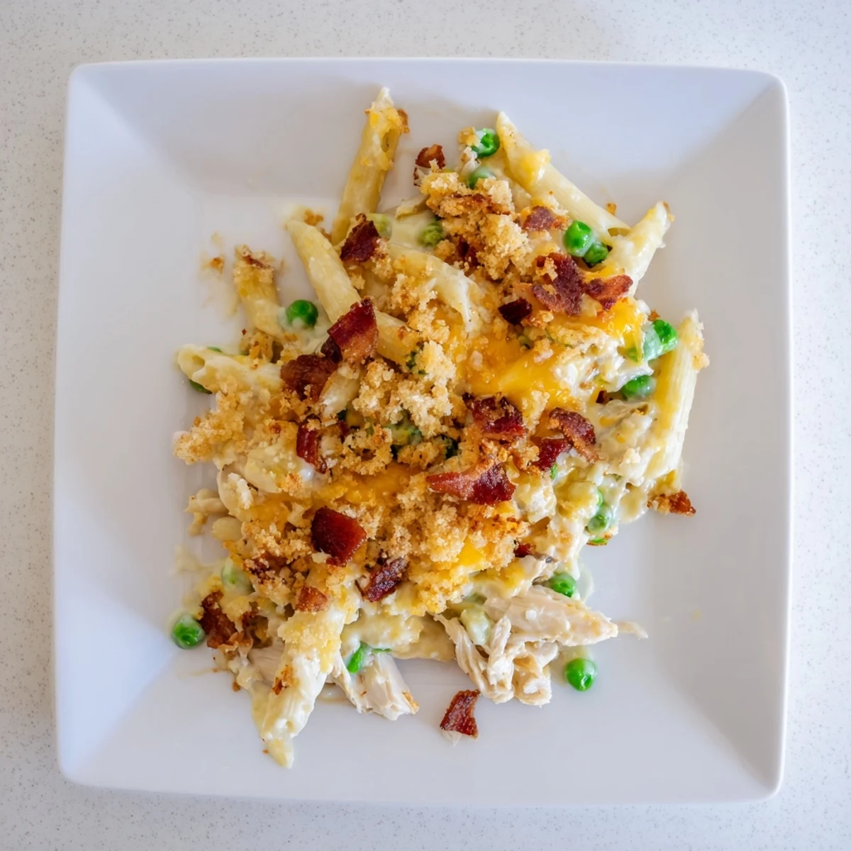 Family-style dish of Crazy Good Casserole bubbling from the oven, with steam rising and melted cheddar cheese stretching.