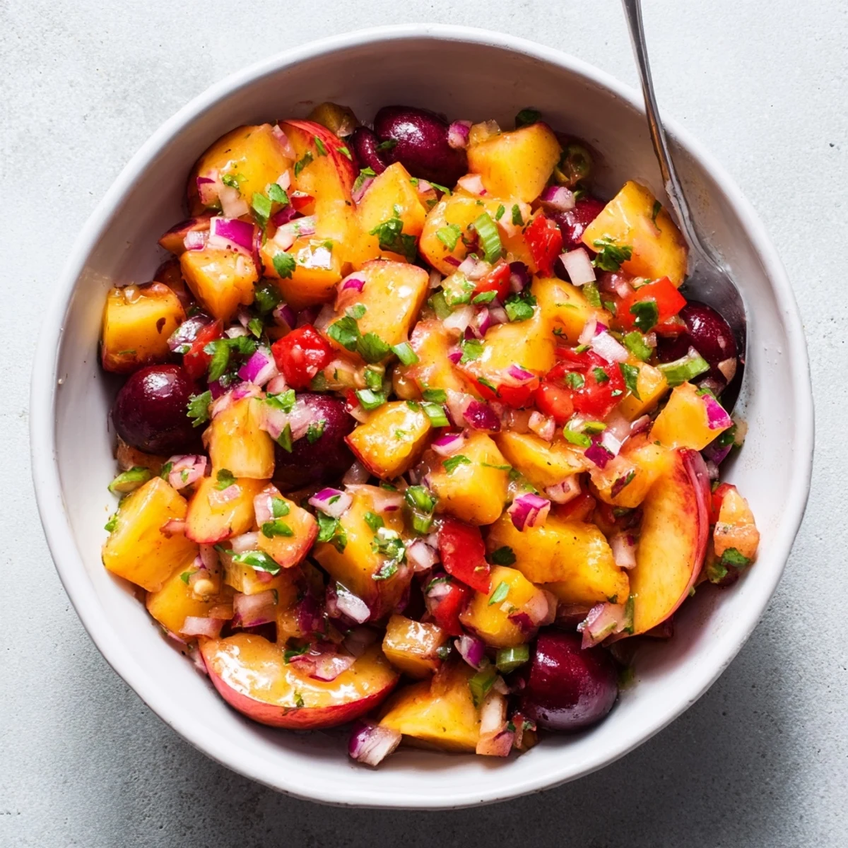 A bowl of Healthy Peach Cherry Salsa with diced peaches, cherries, red onion, and fresh cilantro, served with tortilla chips.