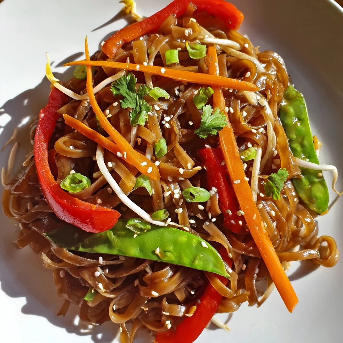 Hot Rice Noodle Stir Fry in a wok garnished with cilantro and sesame seeds.