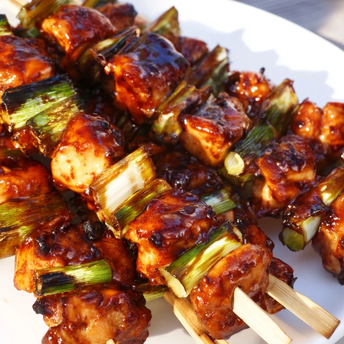 Juicy chicken thigh yakitori pieces alternated with scallions glossy from traditional soy-based glaze