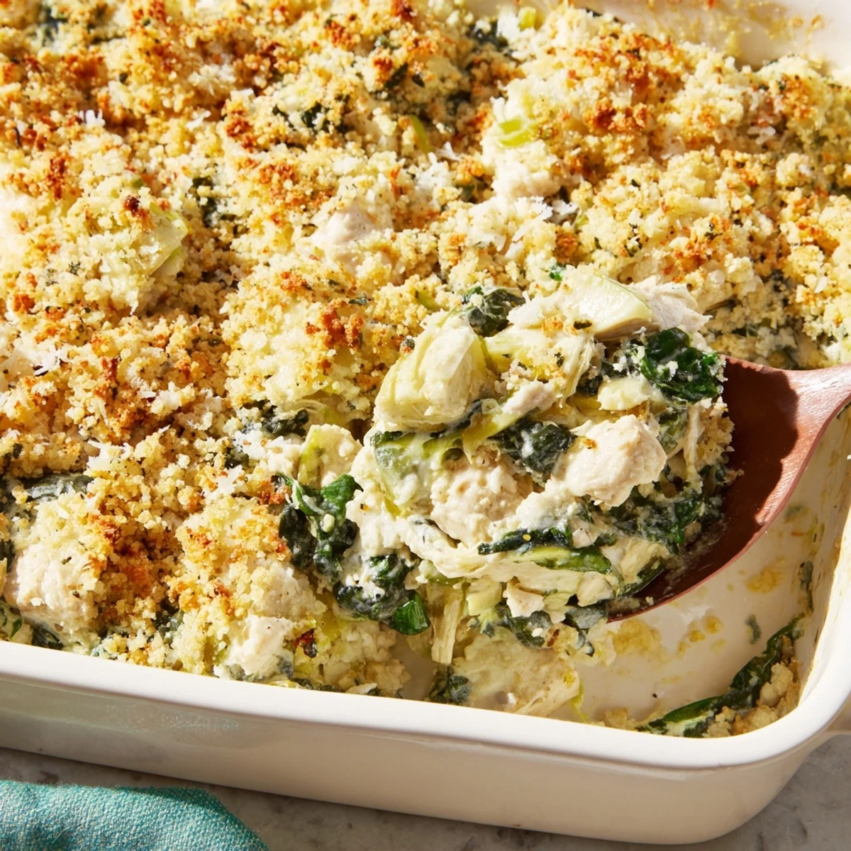 Savory high protein spinach and artichoke chicken casserole garnished with fresh green parsley sprigs