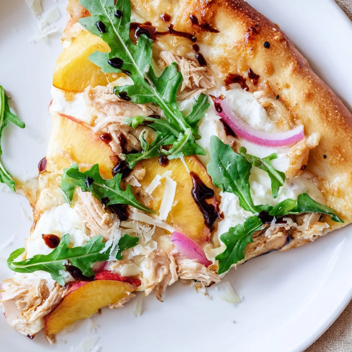 Golden chicken peach ricotta pizza topped with fresh arugula and balsamic glaze drizzle