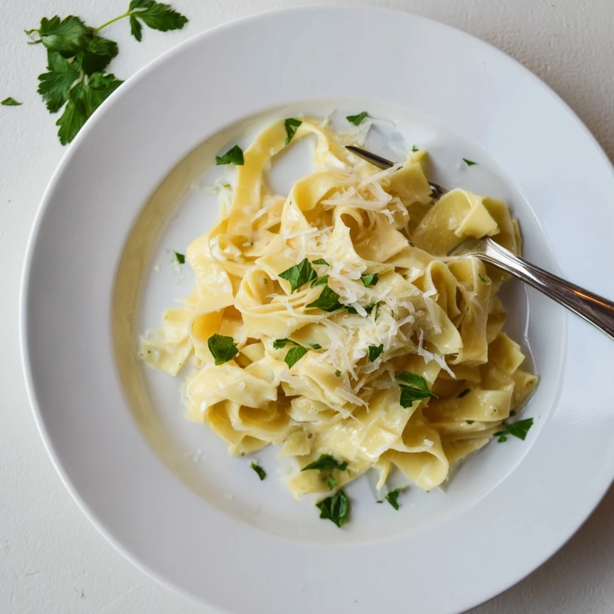 Steaming plate of ultimate creamy fettuccine Alfredo pasta draped in luxurious butter Parmesan sauce