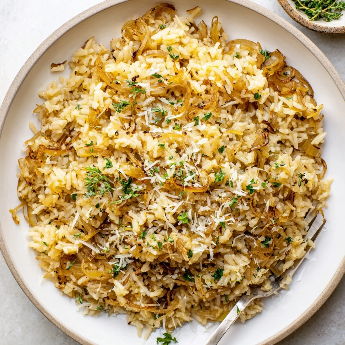 Golden caramelized onions mixed with fluffy French onion butter rice in a white serving bowl