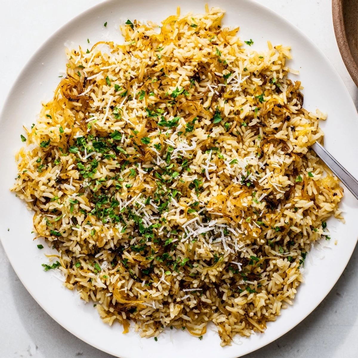 Close-up of French onion butter rice topped with melted Gruyère and fresh green parsley