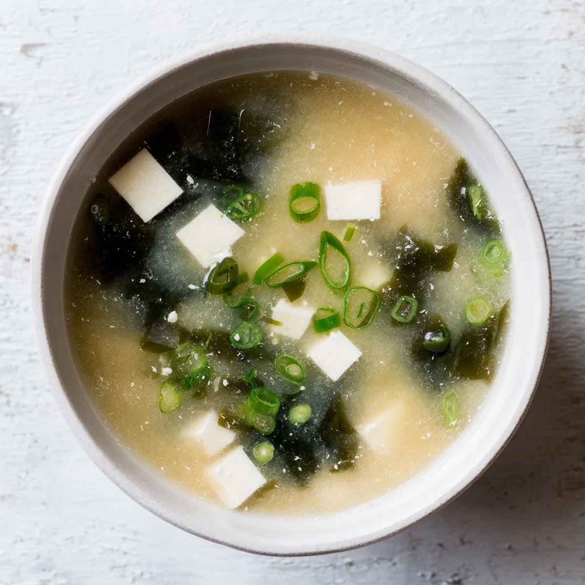 Comforting Japanese miso soup featuring silken tofu, rehydrated wakame seaweed, and fresh scallions