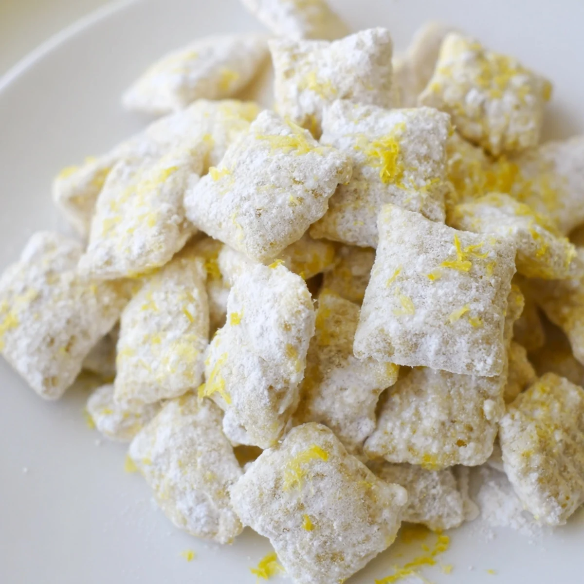 White chocolate lemonade puppy chow snack mix speckled with bright yellow citrus zest