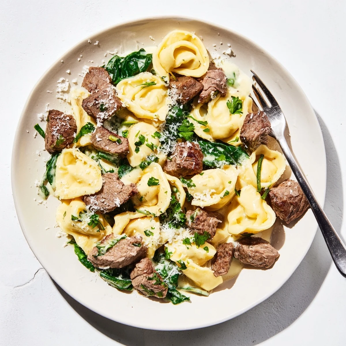 Savory steak and cheese tortellini tossed in velvety garlic cream sauce with spinach