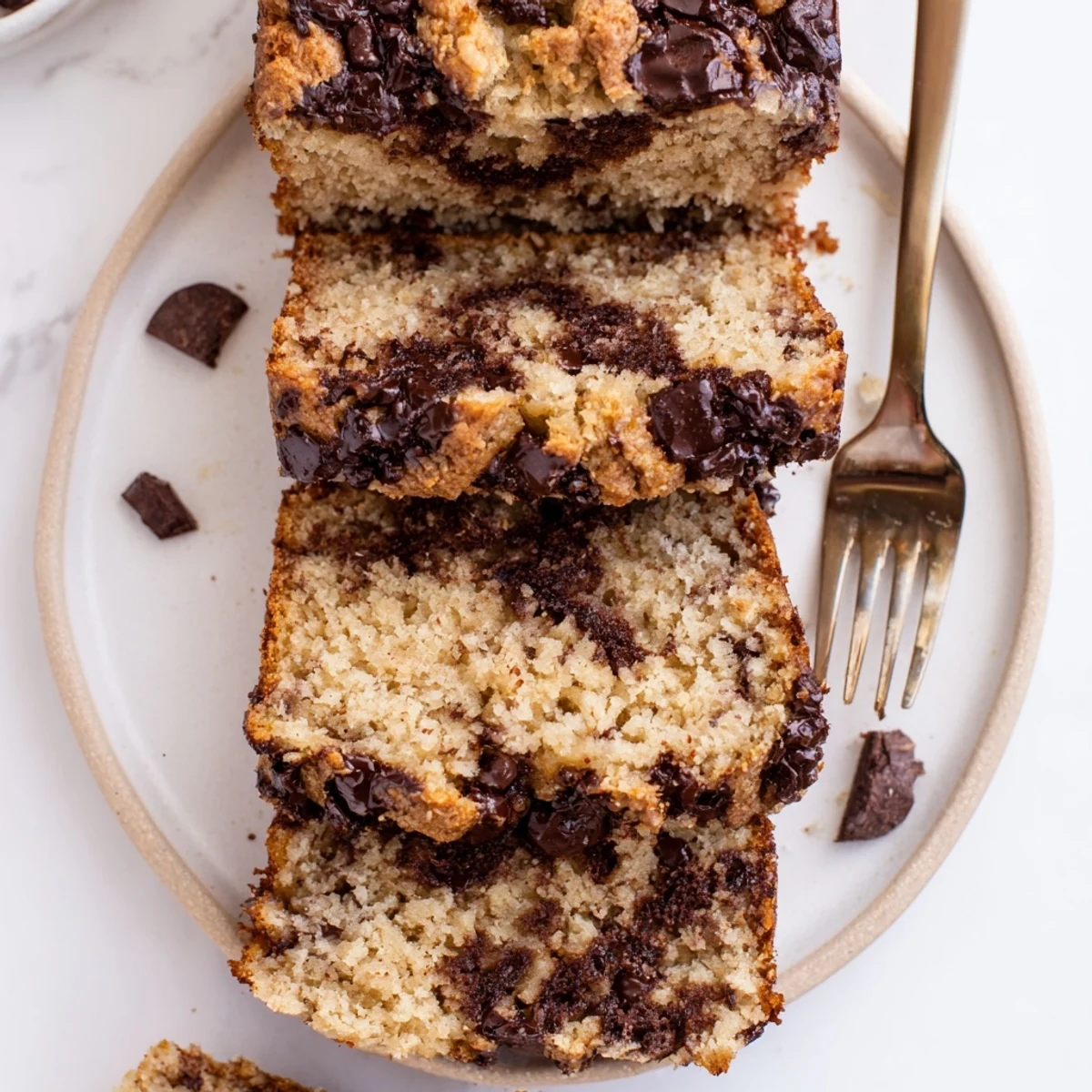 Freshly baked chocolate chip banana bread cooling on a wire rack with golden crust