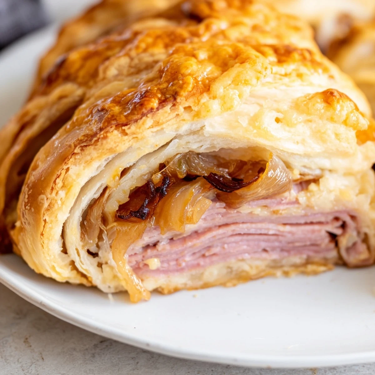 Golden beef and cheese French dip roll ups served with savory au jus dipping sauce on rustic plate