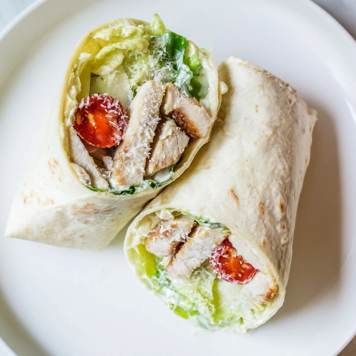 Golden grilled chicken Caesar wraps filled with crisp romaine and creamy dressing on a wooden board