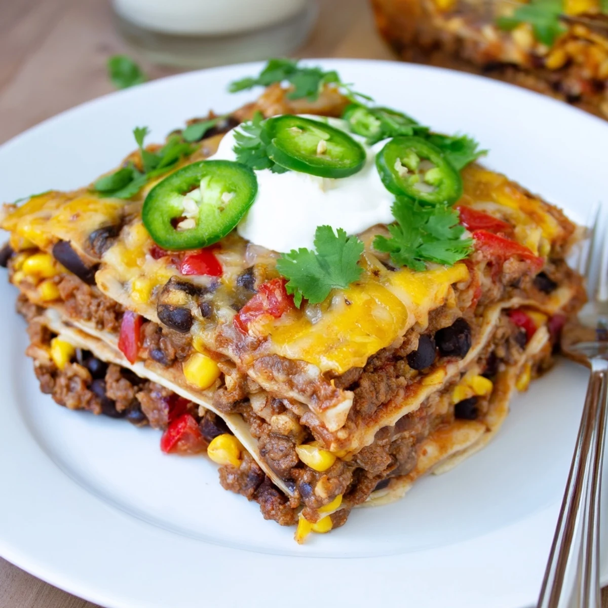 Mexican lasagna fresh from the oven with gooey cheese and colorful Tex-Mex filling.