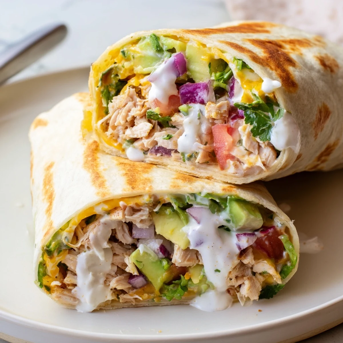 Warm Chicken Avocado Ranch Burritos on skillet, tangy dressing and crisp lettuce