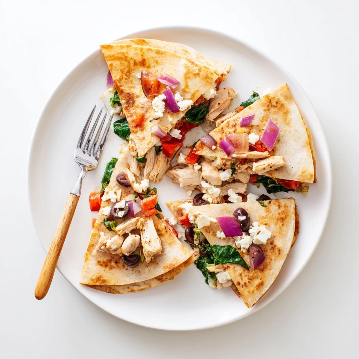 Golden brown Greek chicken quesadillas featuring melty mozzarella and feta cheese