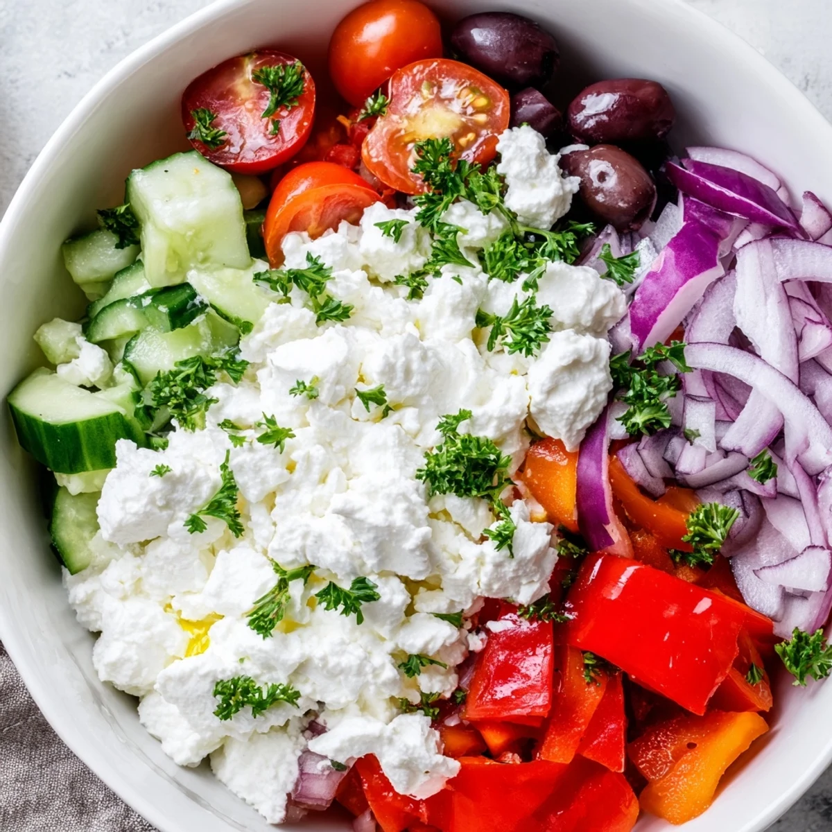 Greek Salad Cottage Cheese Bowl featuring fresh tomatoes, cucumber, and Kalamata olives over protein-rich cottage cheese