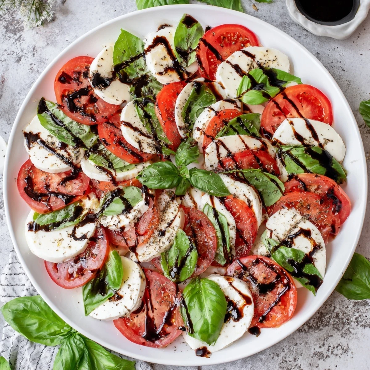 Festive Christmas candy cane Caprese salad with fresh mozzarella, tomatoes, and basil arranged in a holiday candy cane shape drizzled with balsamic glaze