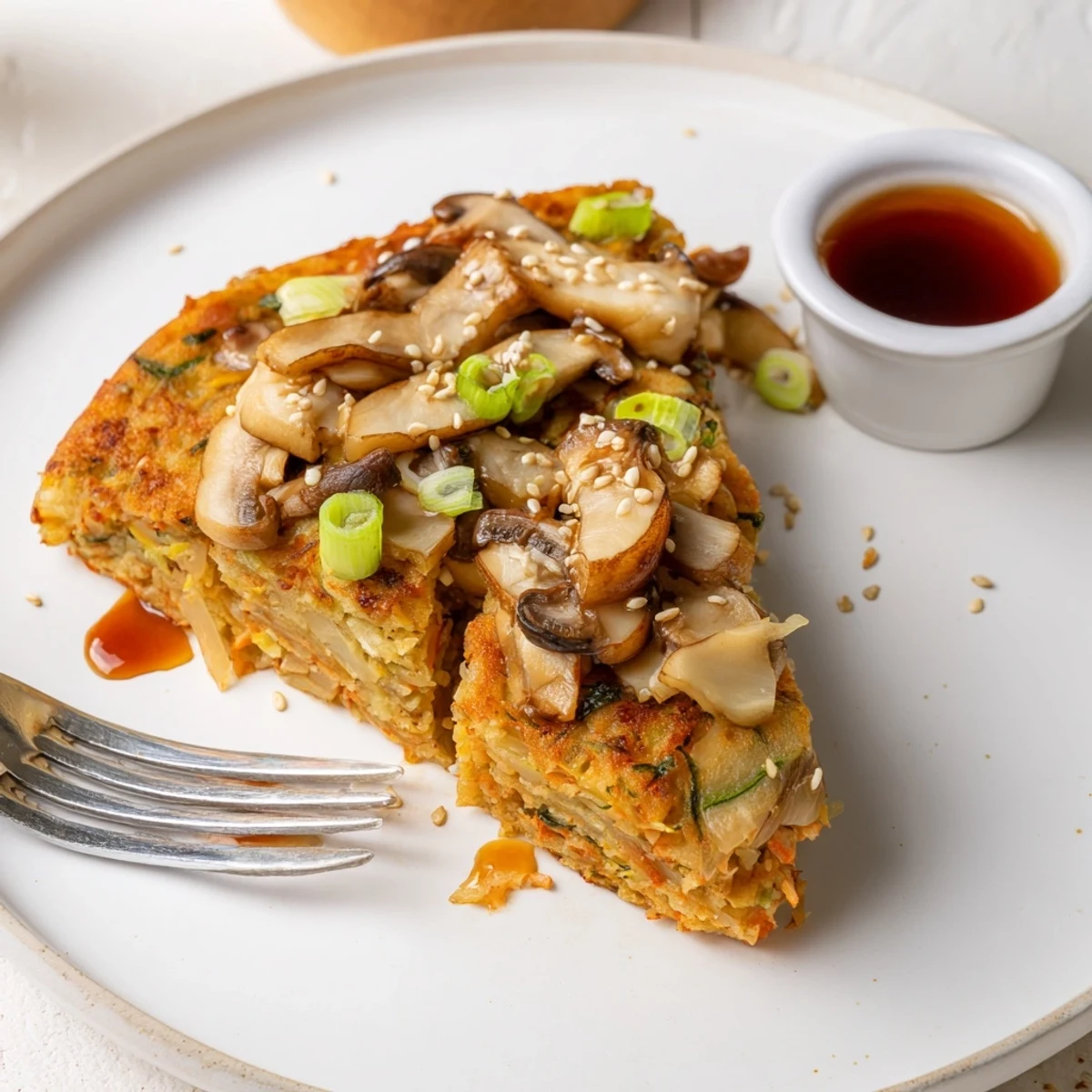 Crispy Vegan Kimchi Pancake With Tamari Mushrooms topped with scallions, steaming.