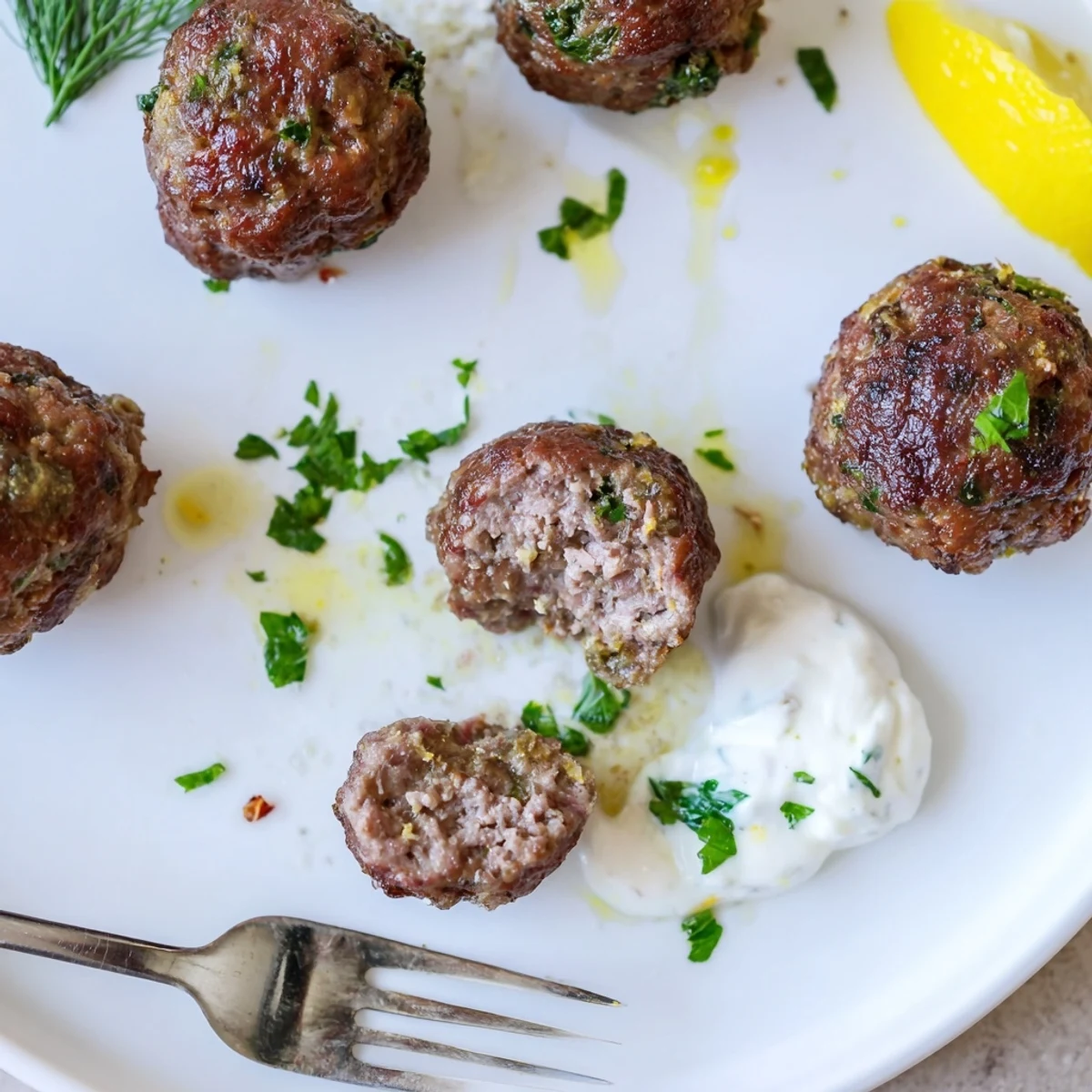 Greek Style Beef Meatballs glistening with olive oil, served with tangy yogurt