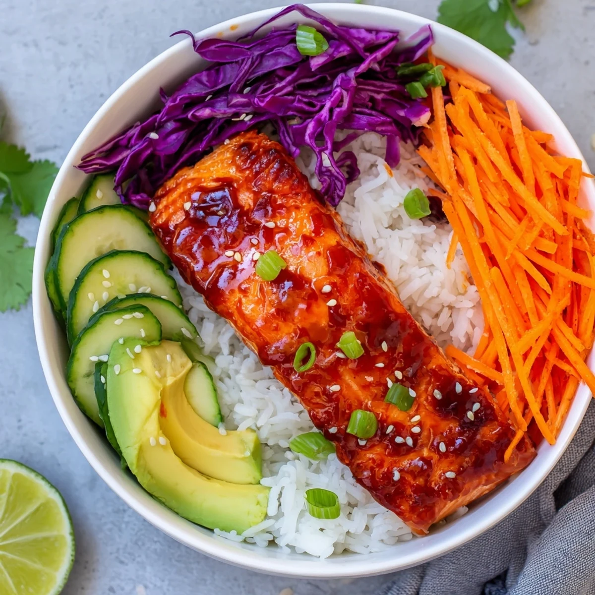 Tender caramelized salmon in Sriracha Honey Glazed Salmon Bowls with crisp shredded cabbage and lime