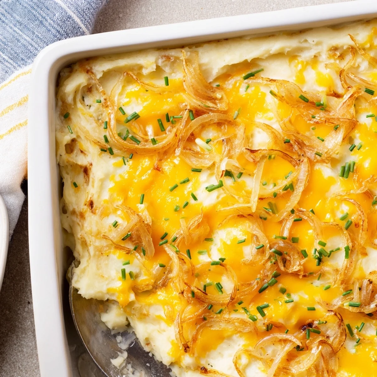 Creamy Cheesy Onion Mashed Potato Casserole topped with golden melted cheddar